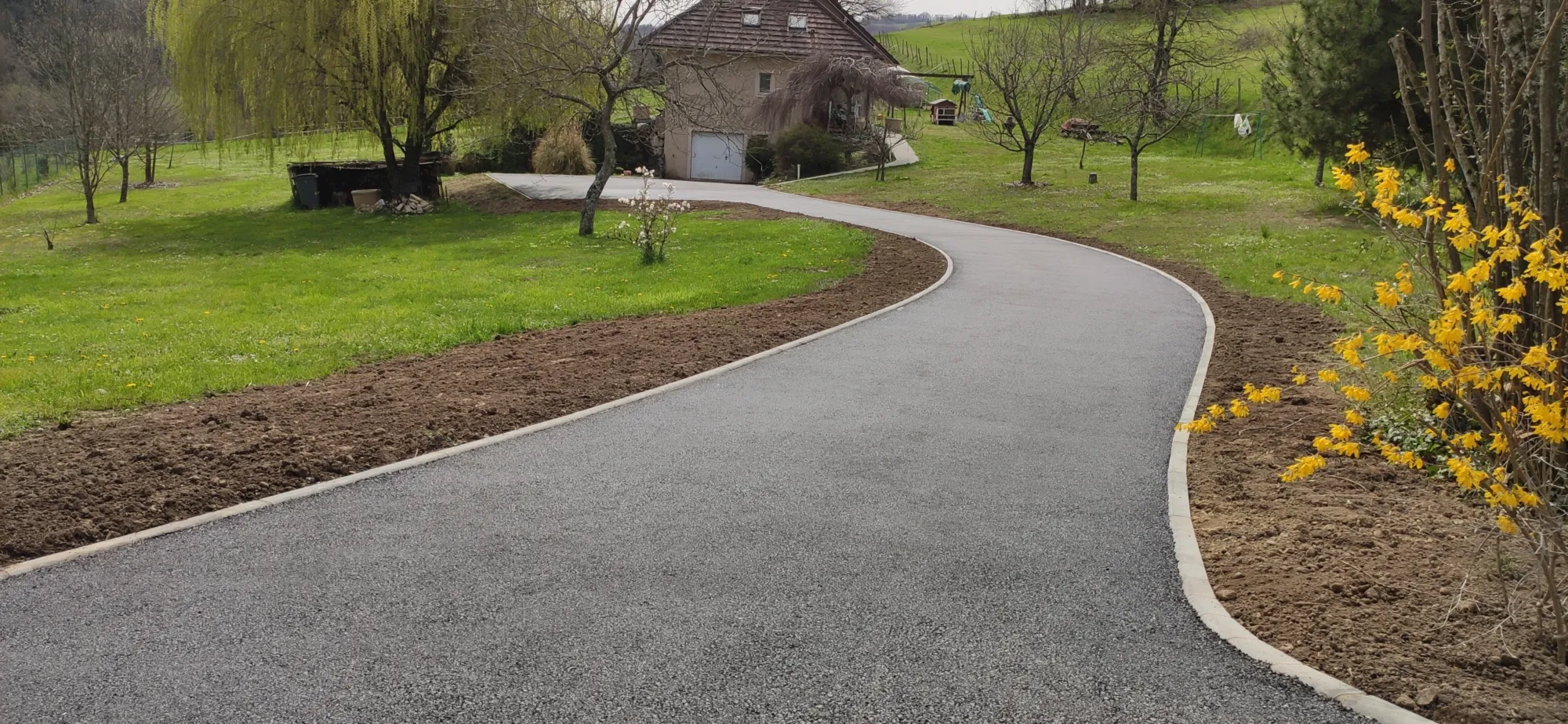 Chemin goudronné menant vers une maison